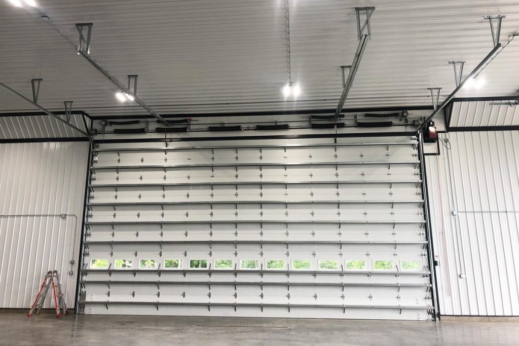 A large commercial overhead door with insulated sandwich panels and windows