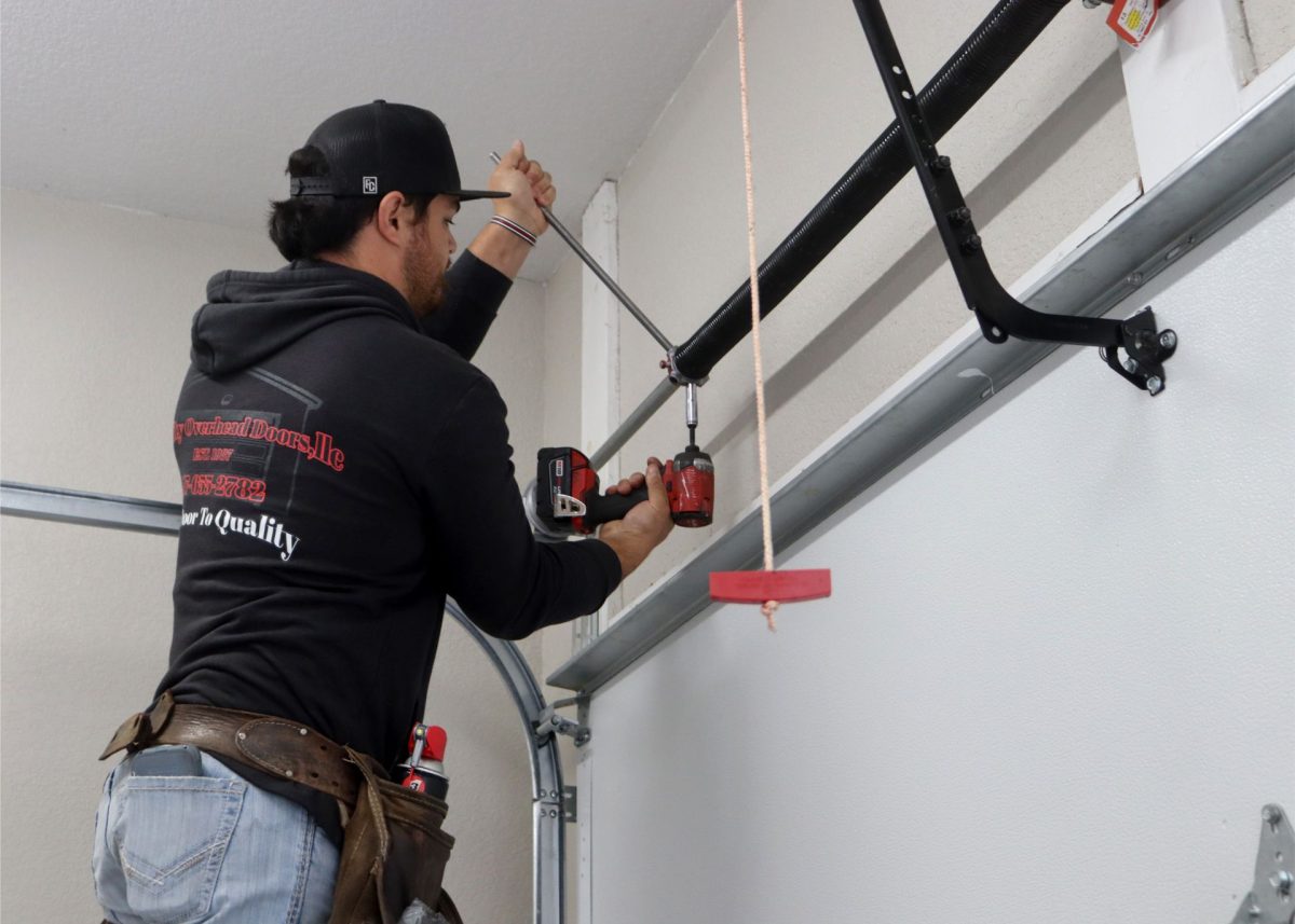 A technician servicing residential garage door spring in outside of Springfield, Missouri