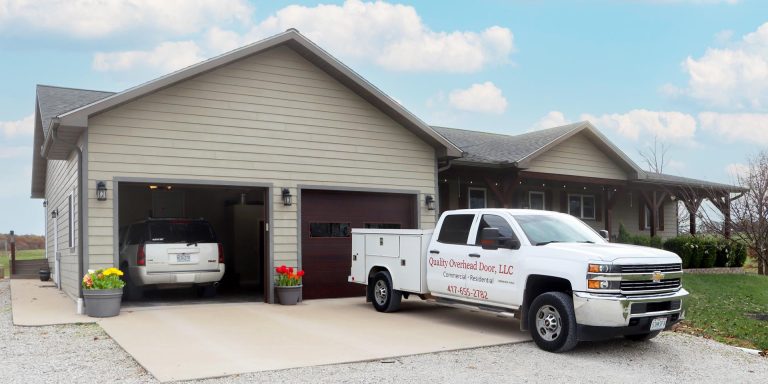 A Quality Overhead Door LLC work truck in front of of a residential garage door in Seymour, Missouri